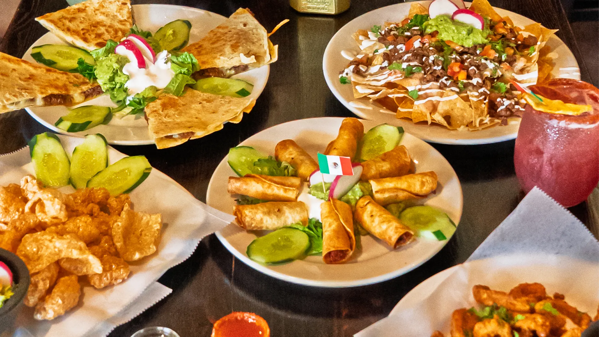A table spread of El Tarasco appetizers: quesadillas, carne asada nachos, flautas and chicharrones